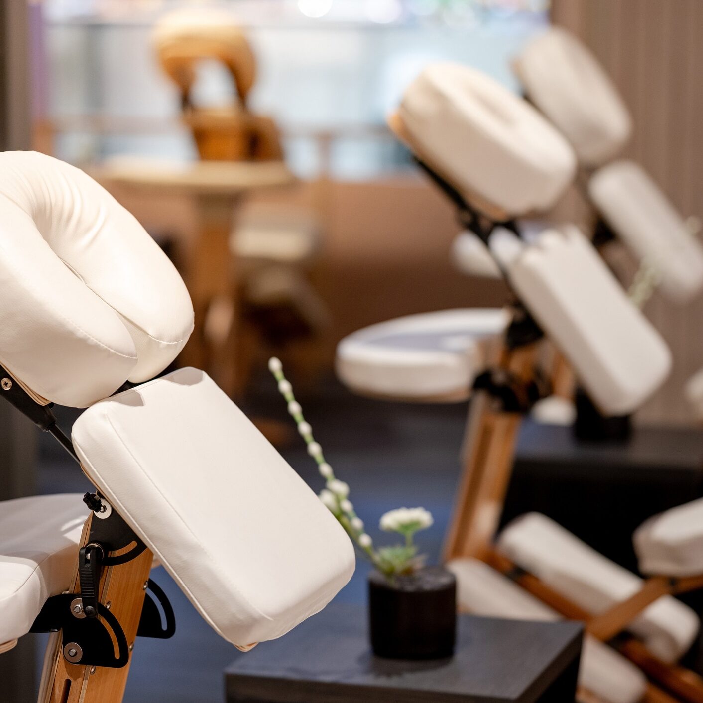 Portable adjustable massage chair in a cozy spa Portable adjustable massage chair in a cozy spa. Furniture and equipment for massage treatment service. Place for body care and relaxing activity